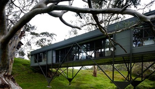 When Max Pritchard's clients approached him to design a small house overlooking a picturesque creek on their farm, they never imagined that he would perch them above the waterway,but they've come to love his lofty solution.